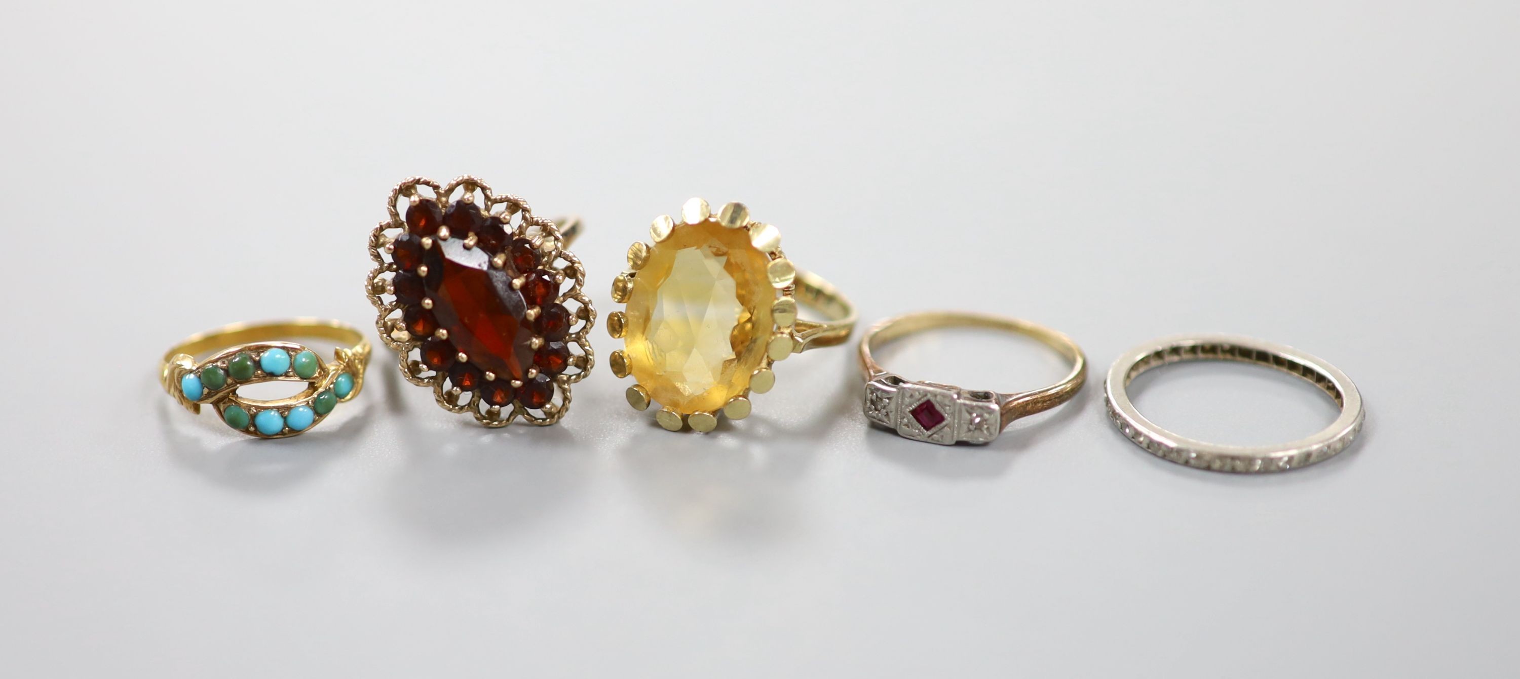 Three assorted 9ct gold and gem set rings including garnet and citrine, gross 11.4 grams, a yellow metal and turquoise ring, gross 1.4 grams and a white metal and diamond chip set full eternity ring, gross 2.2 grams.